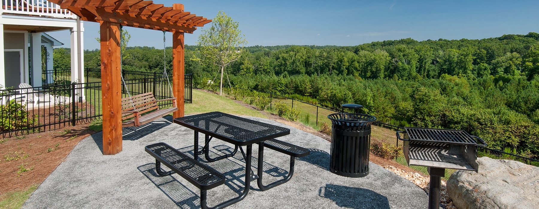 overlook area with a wooden bench swing and with views of near forest