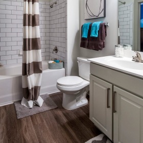bathroom on wood-style flooring with a near large tub